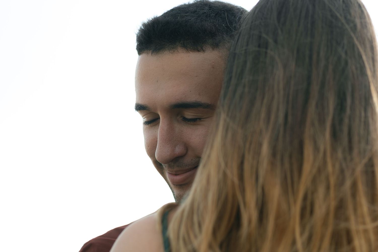 A tender close-up moment between two people with soft lighting and gentle expressions.