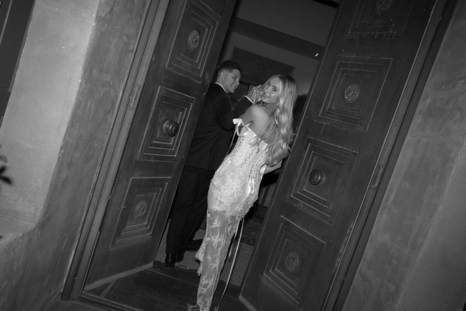 A sequence of black and white surveillance camera stills showing a figure moving through a dimly lit hallway.