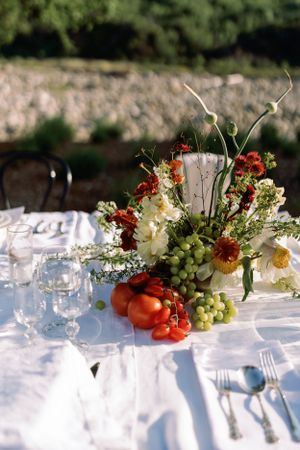 Elegant table setting with fresh floral centerpiece and fruit arrangements.
