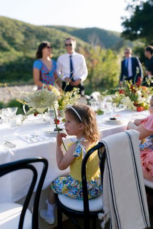 Outdoor wedding reception table setting with mountain scenery in background.