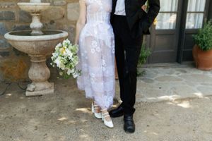 Wedding couple's formal attire detail shot showing white dress and black suit.