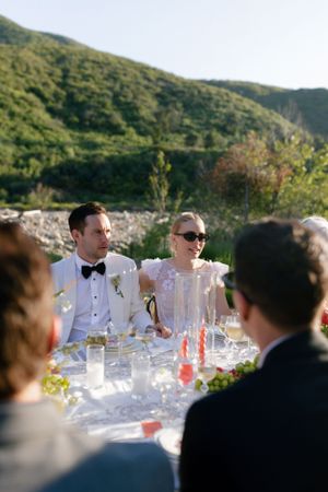 Guests enjoying formal outdoor celebration with mountain backdrop.