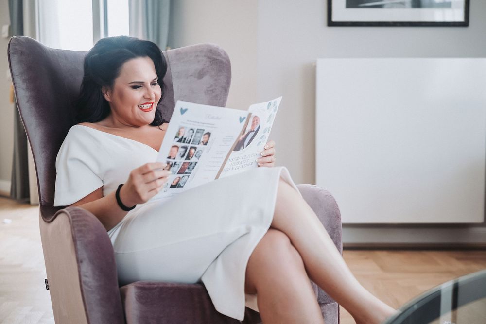 A person relaxes on a couch while reading papers in a cozy living room setting.