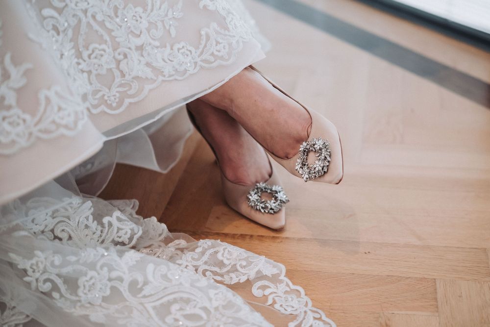 A close-up view of delicate white lace trim being placed along a wooden surface.