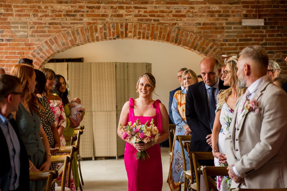 Wedding ceremony taking place in an elegant brick venue with guests in attendance.