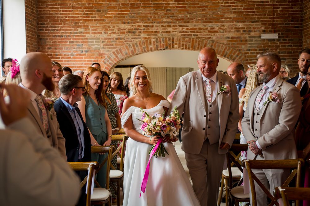 Celebration unfolds in a beautiful brick-lined venue with warm lighting and arched windows.