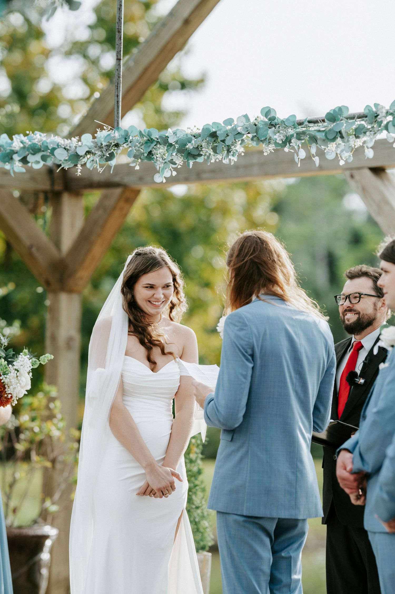 A series of candid wedding ceremony moments captured under a rustic wooden pergola with delicate floral decorations.