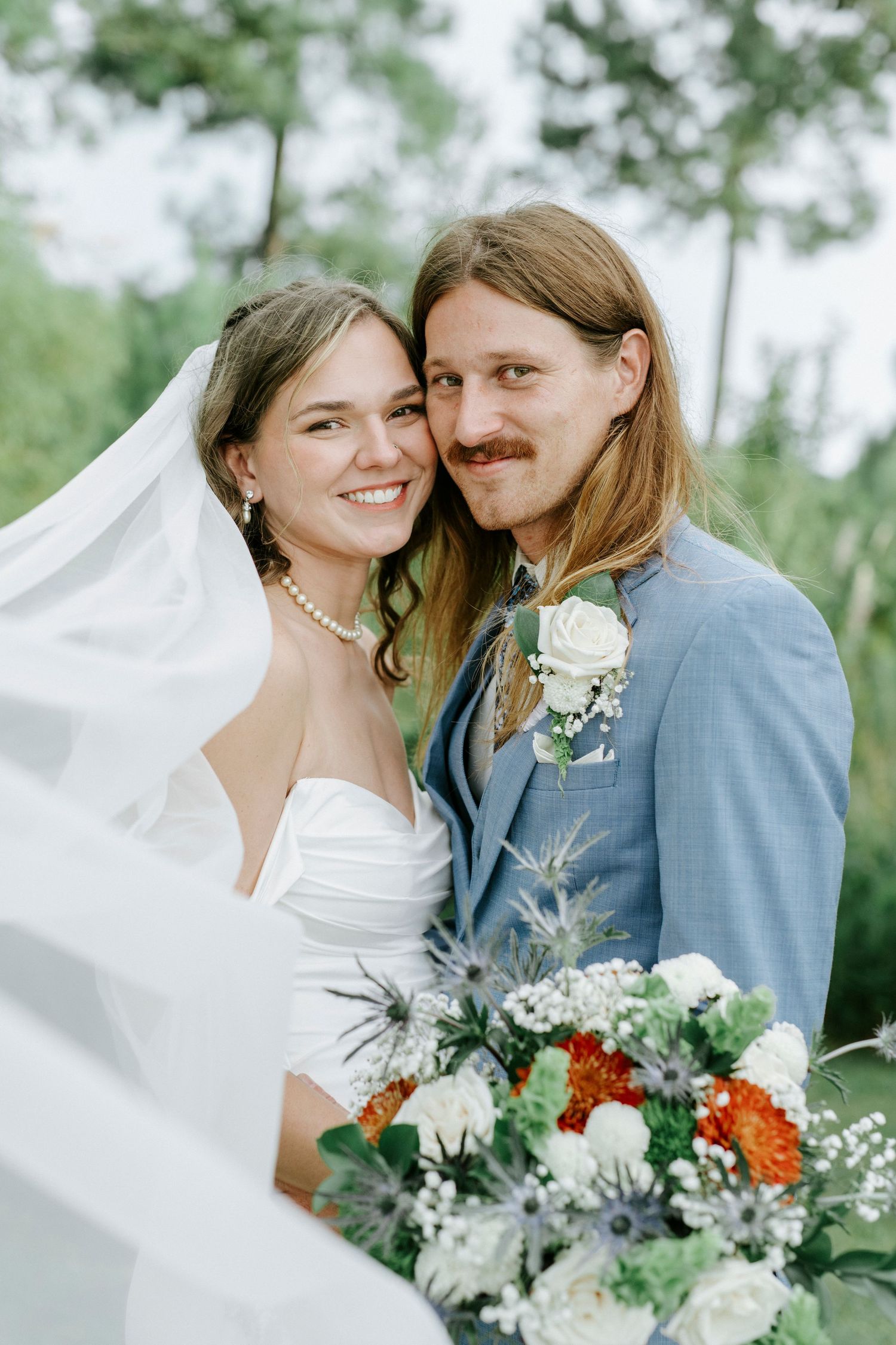A romantic wedding photo series showing a couple with a beautiful bouquet of white and orange flowers against a green backdrop.
