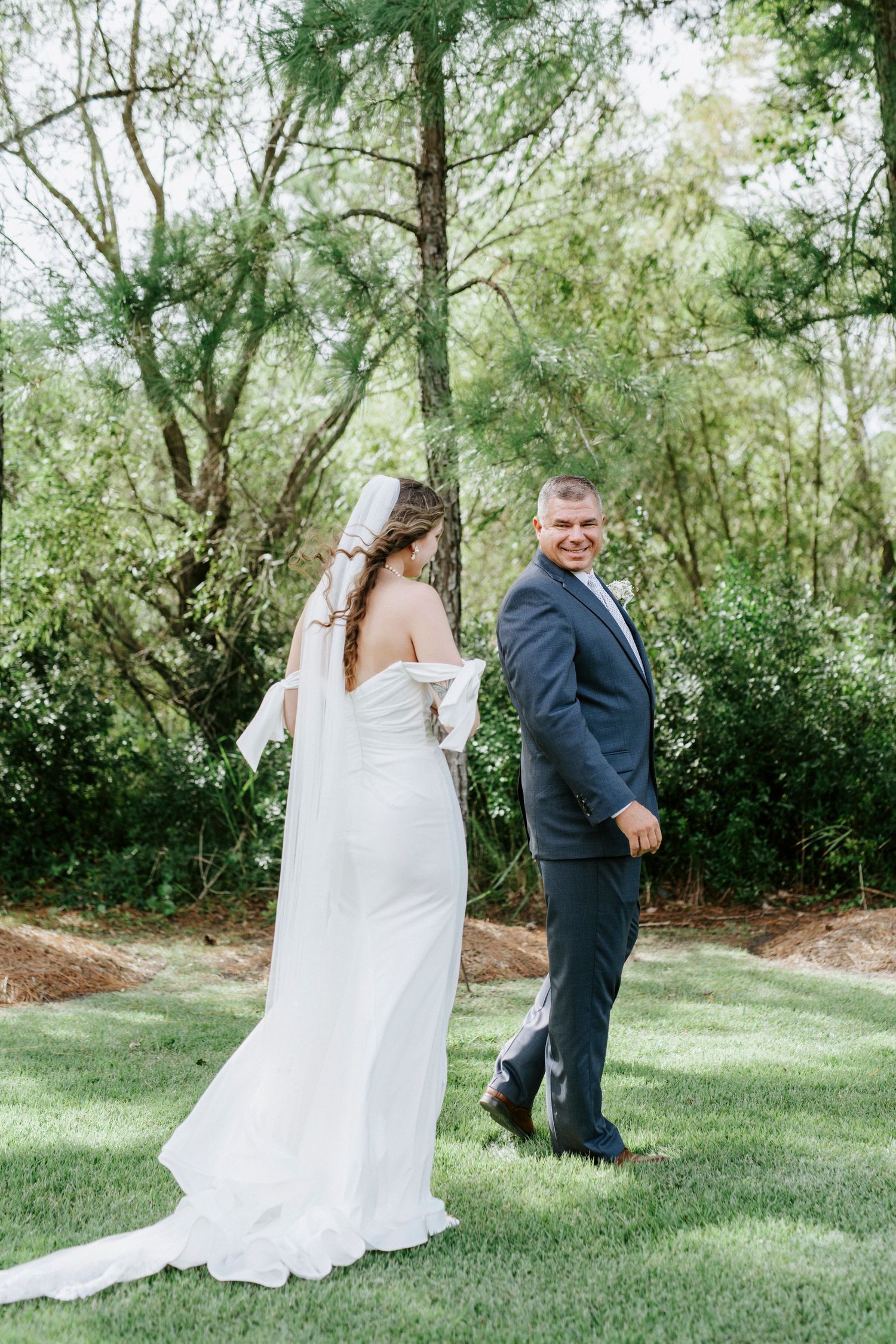 A couple shares a playful first look moment in a garden setting during their wedding photoshoot.