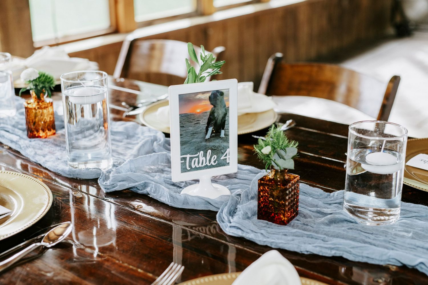 Table settings at an upscale restaurant with elegant glassware, white plates, and decorative table runners.