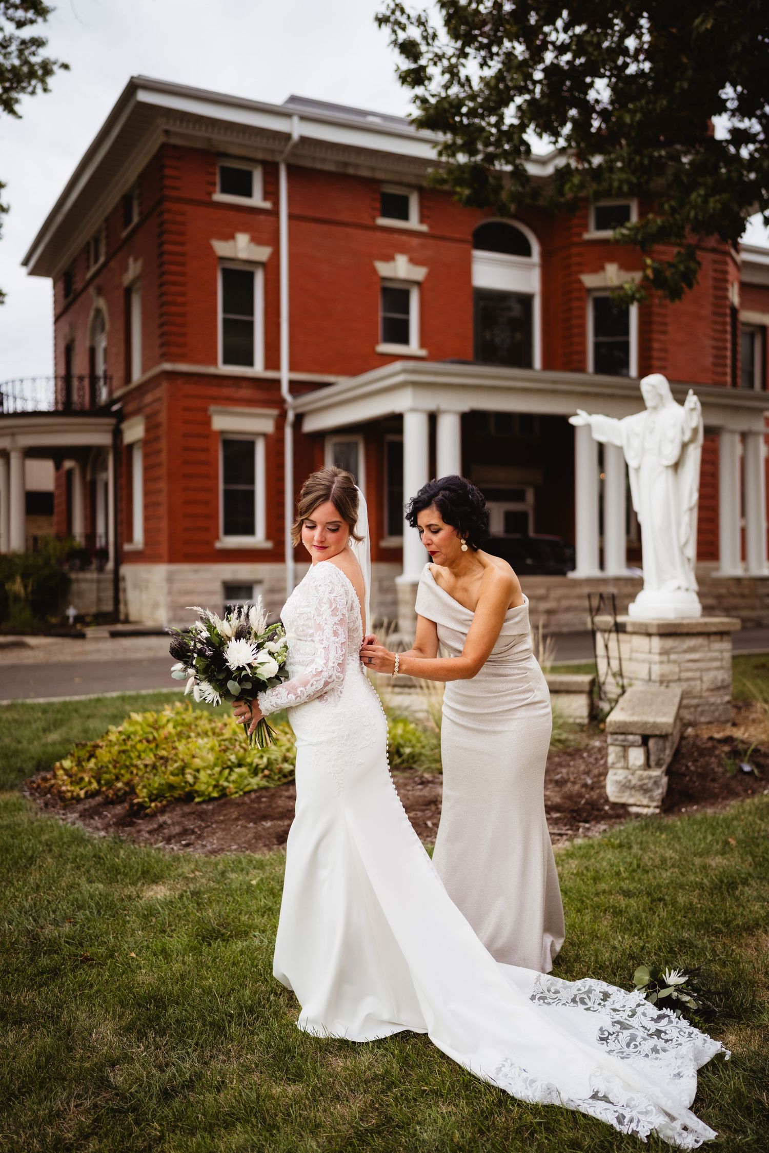 A series of wedding photos showing two people in white dresses walking and posing together on the grounds of a brick building.