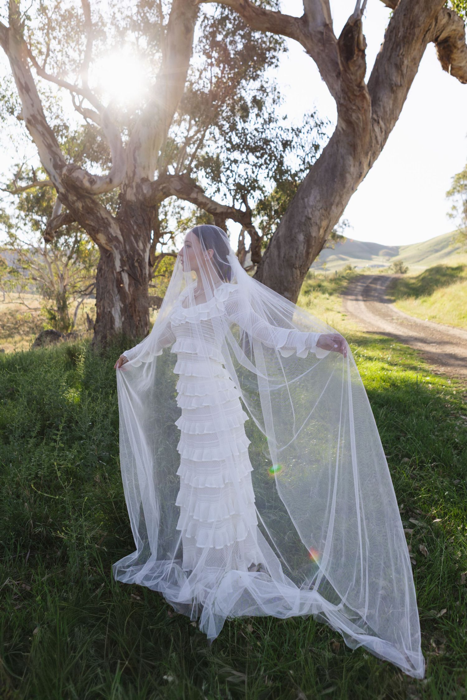 Bride under tree with veil over her face at Scone NSW Country wedding