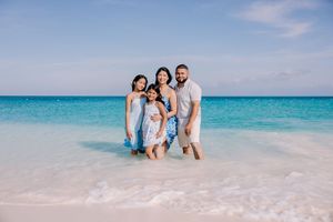 Family enjoying the crystal clear turquoise waters of a tropical beach.