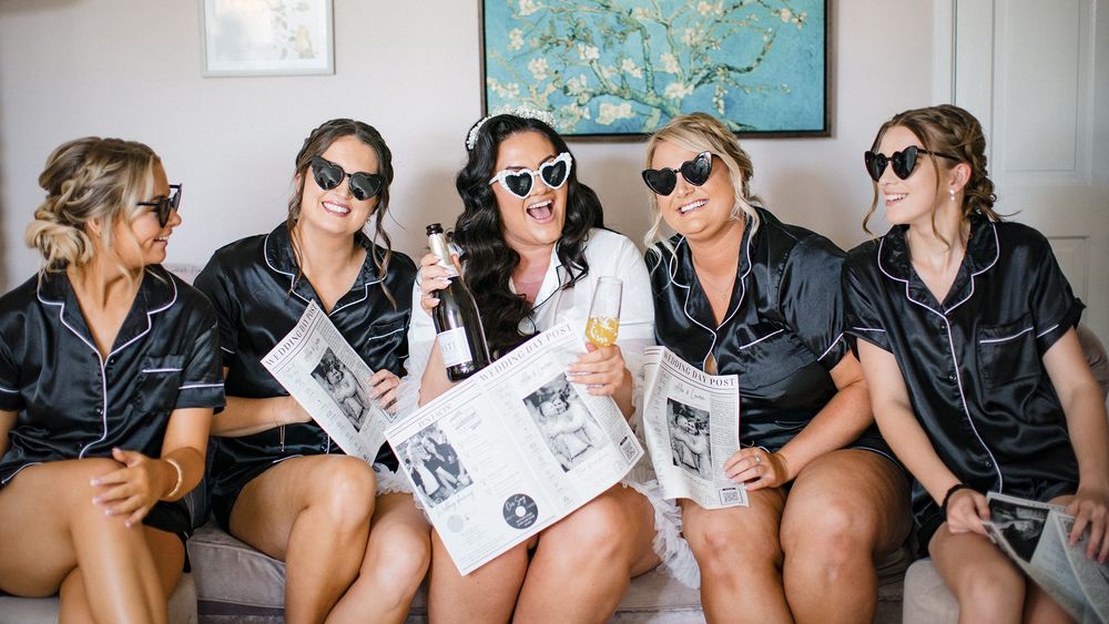 Bridesmaids relaxing together during wedding morning preparations in matching robes