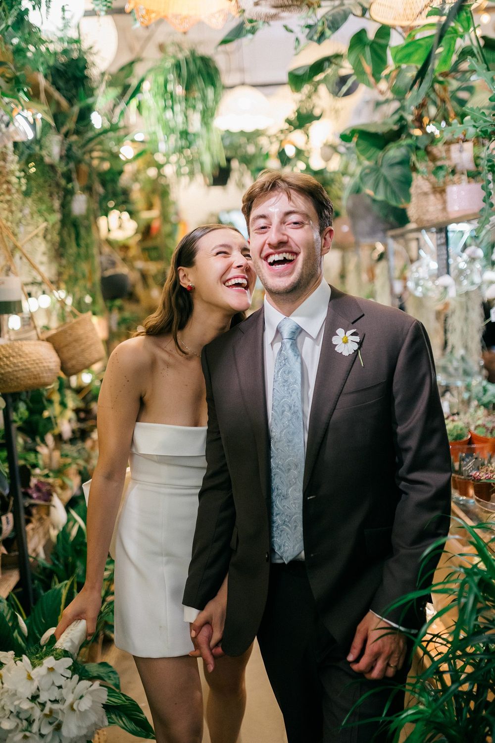 Joyful newlyweds laughing together during romantic wedding portraits with natural light