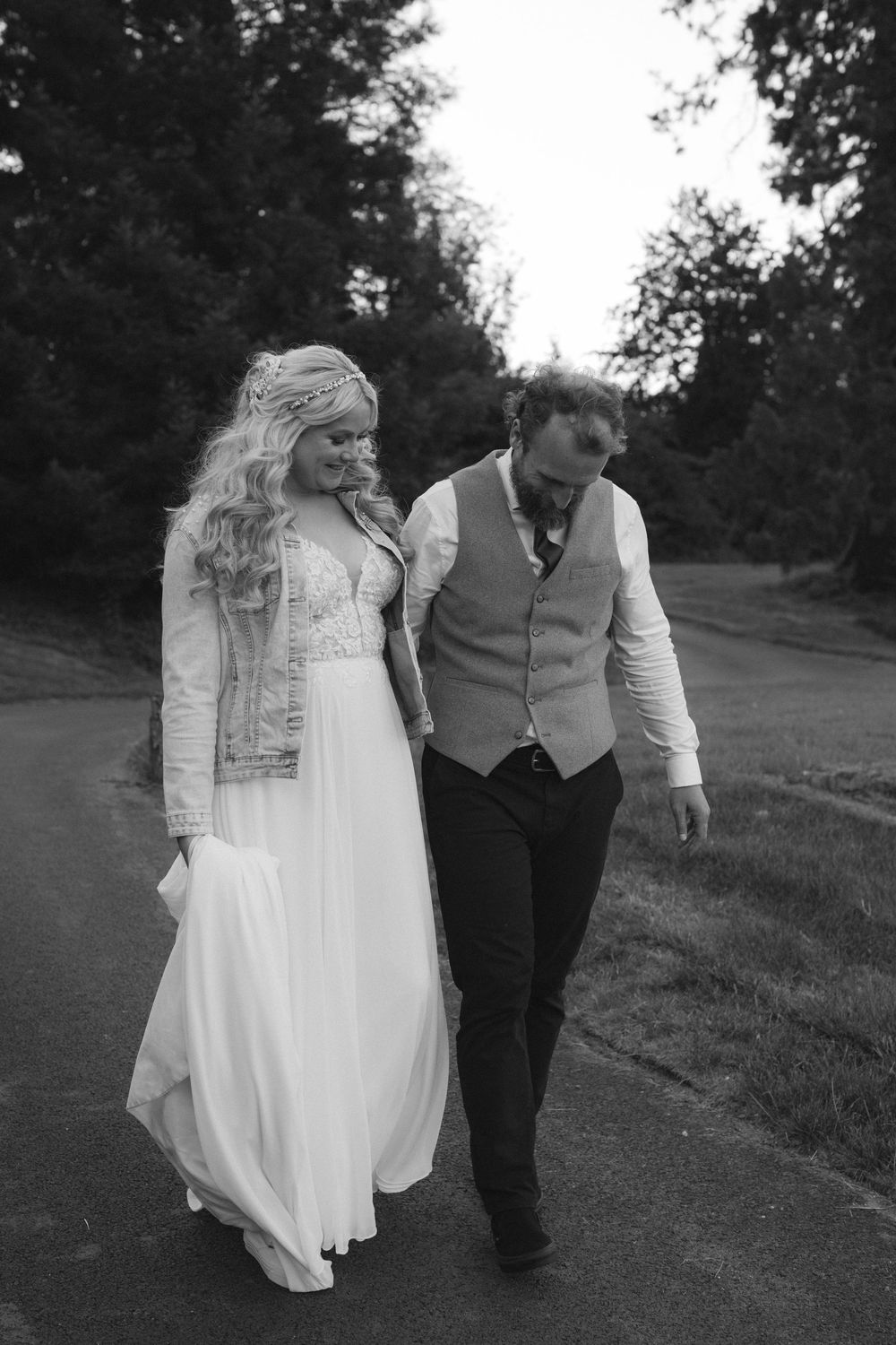 Romantic black and white wedding portrait of newlyweds walking together outdoors