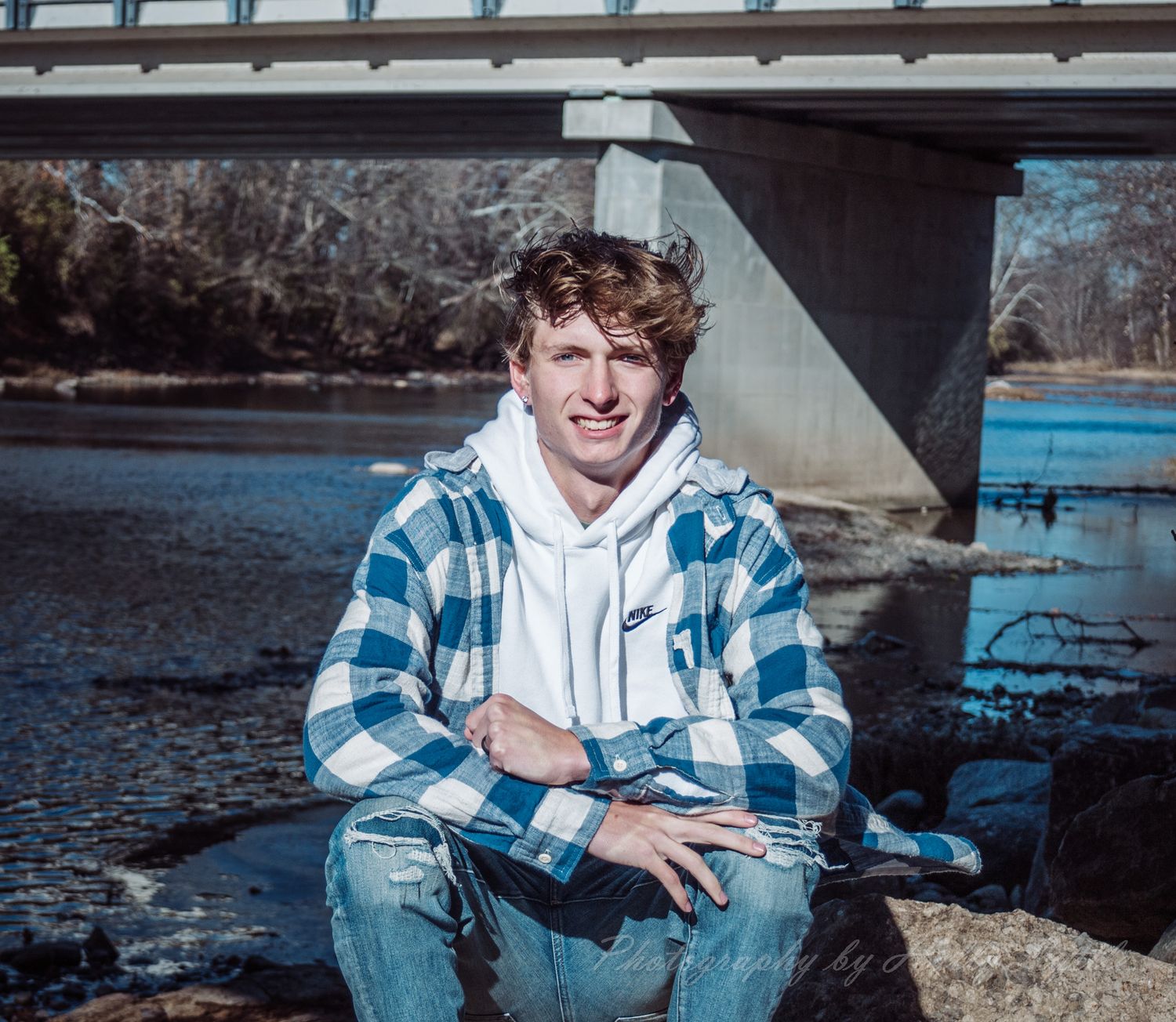 A series of outdoor portraits showing someone in a blue plaid shirt and jeans sitting by a lake on a sunny day.