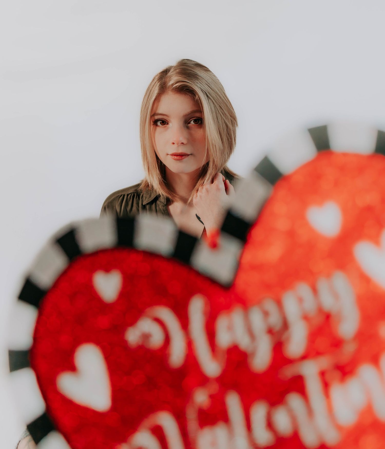 Abstract red heart shapes and text on a blurred white background create a romantic design.