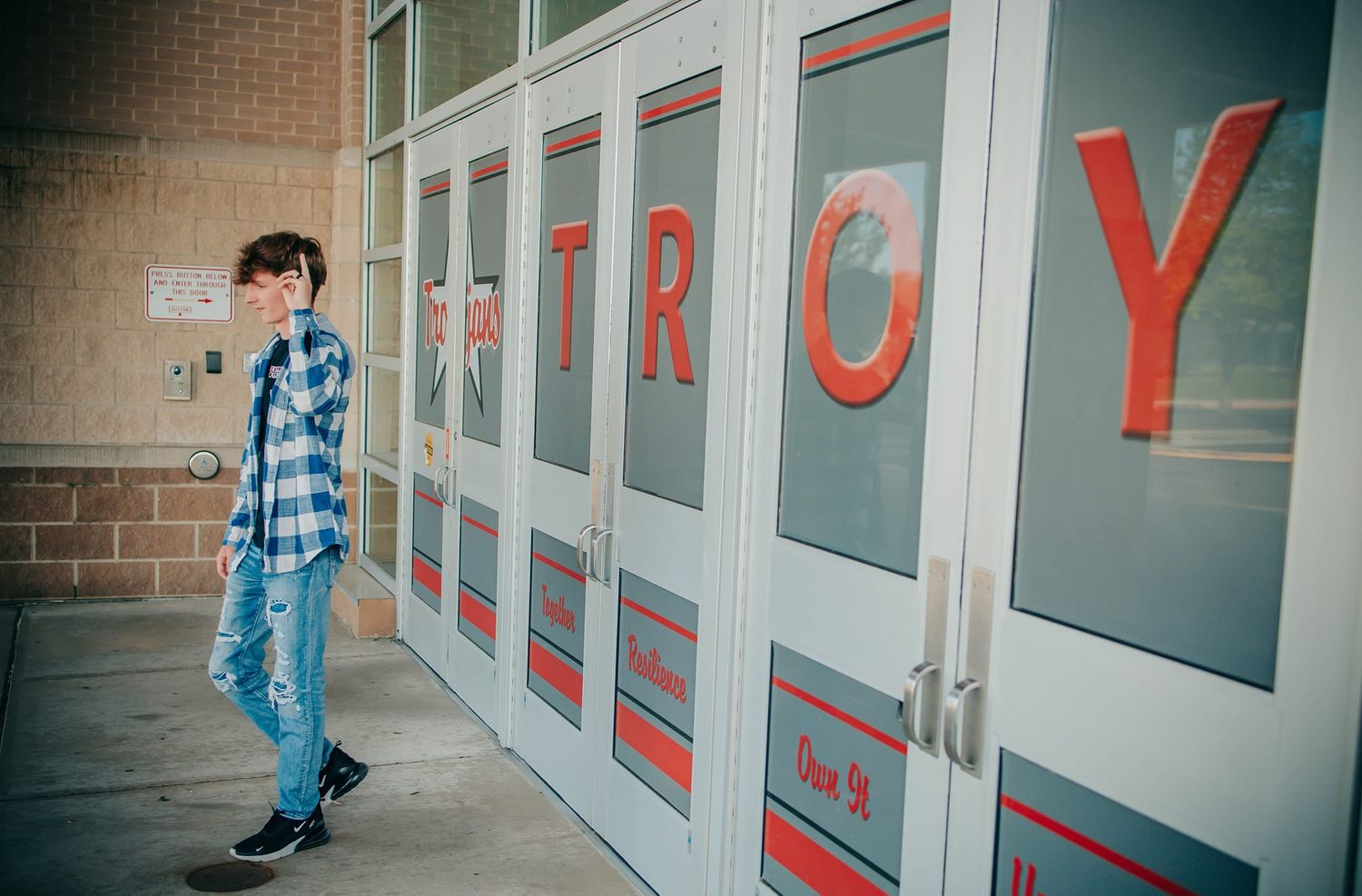 Walking shots along a brick building exterior with blue lettering signage.