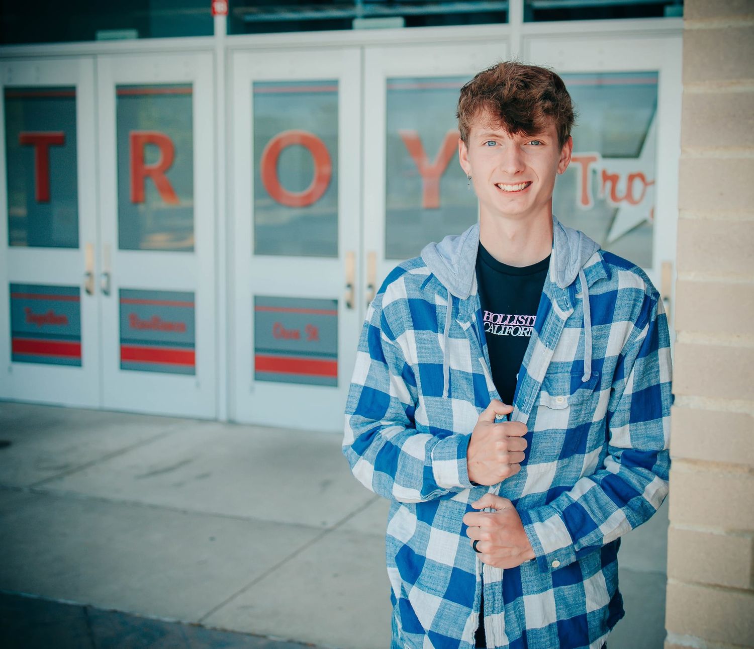 Casual poses along a commercial storefront with red lettering.