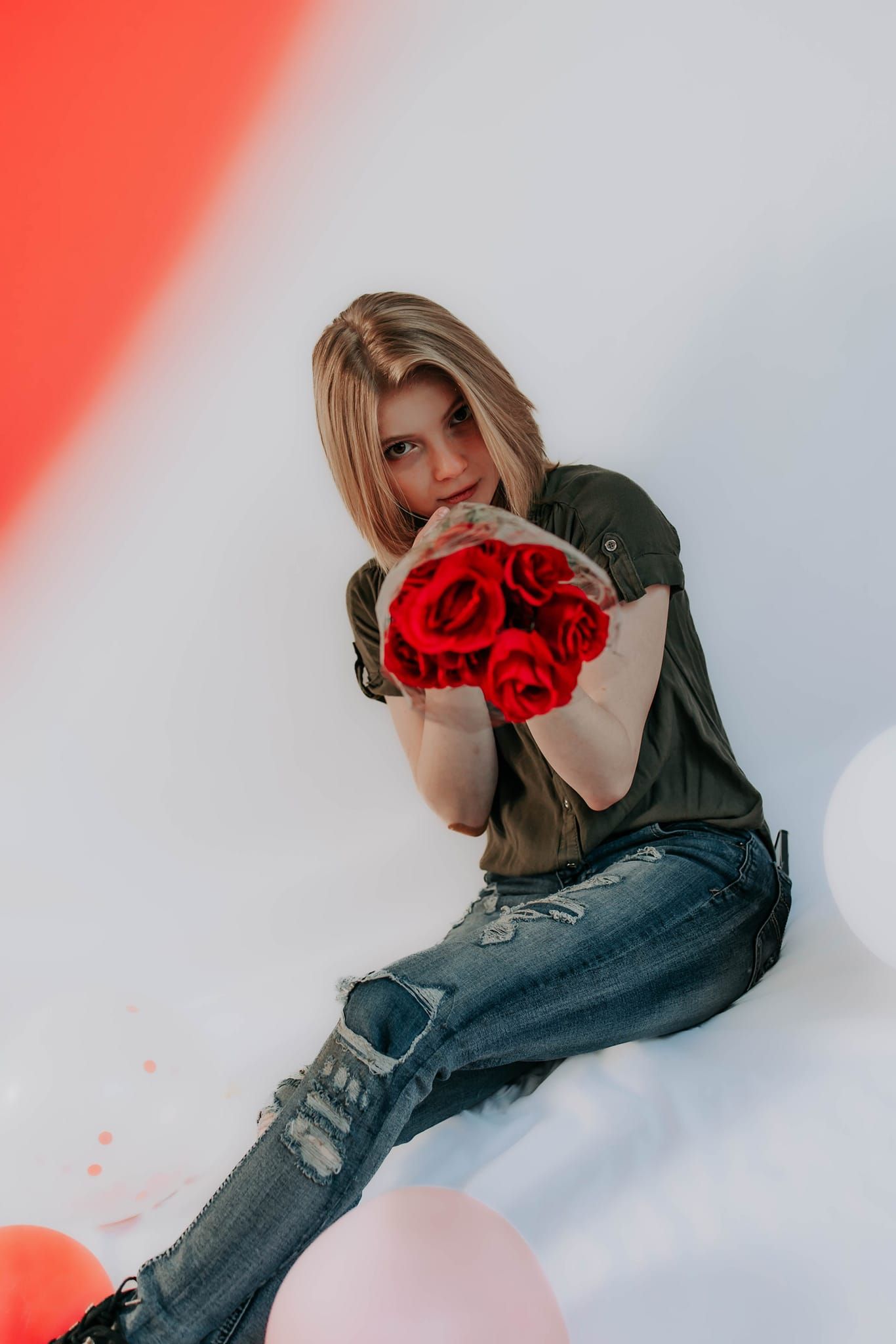 Artistic portrait series with red lighting effects against a white backdrop.