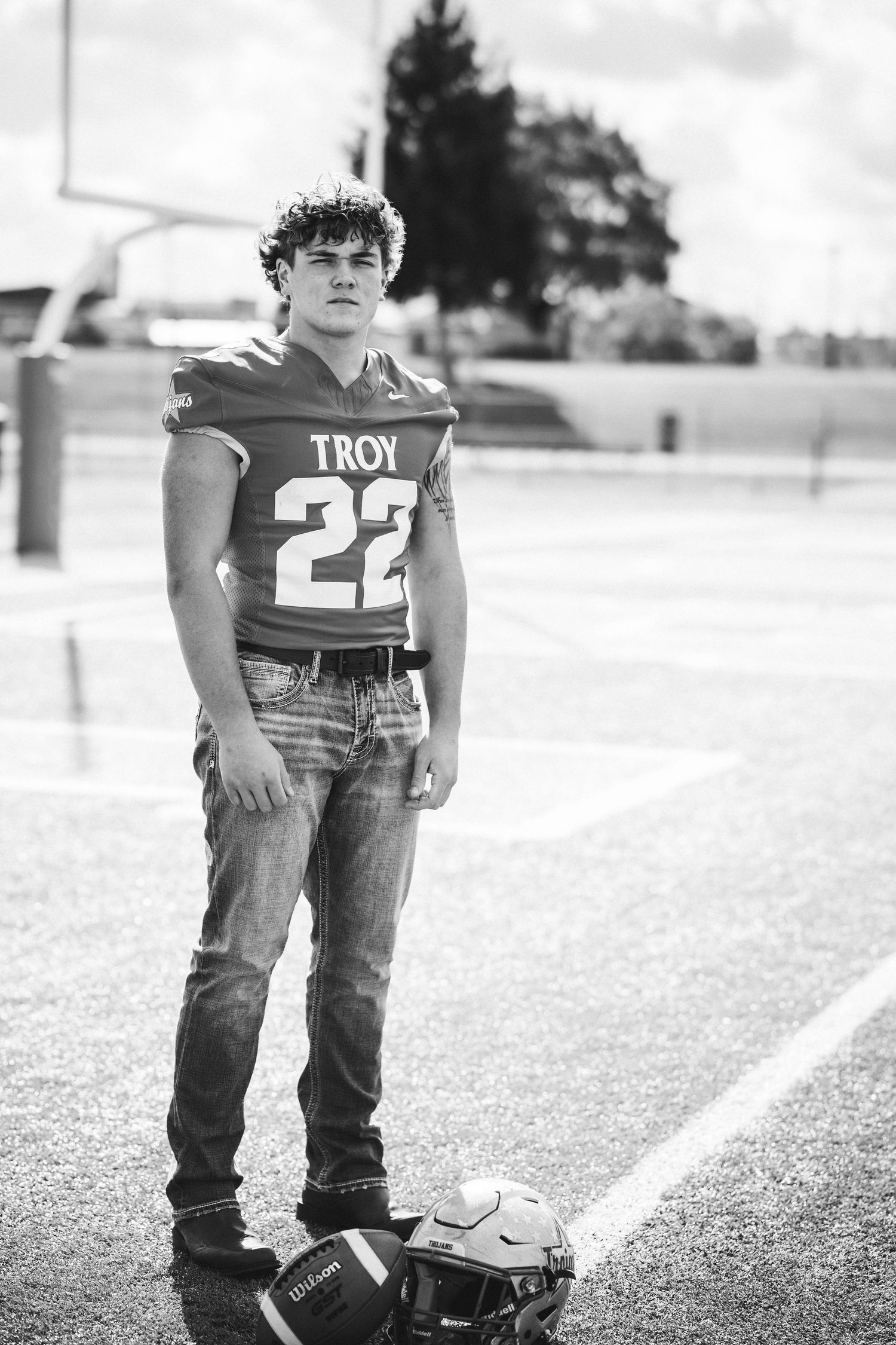 A black and white photo showing football equipment and cleats on a field with white lines.