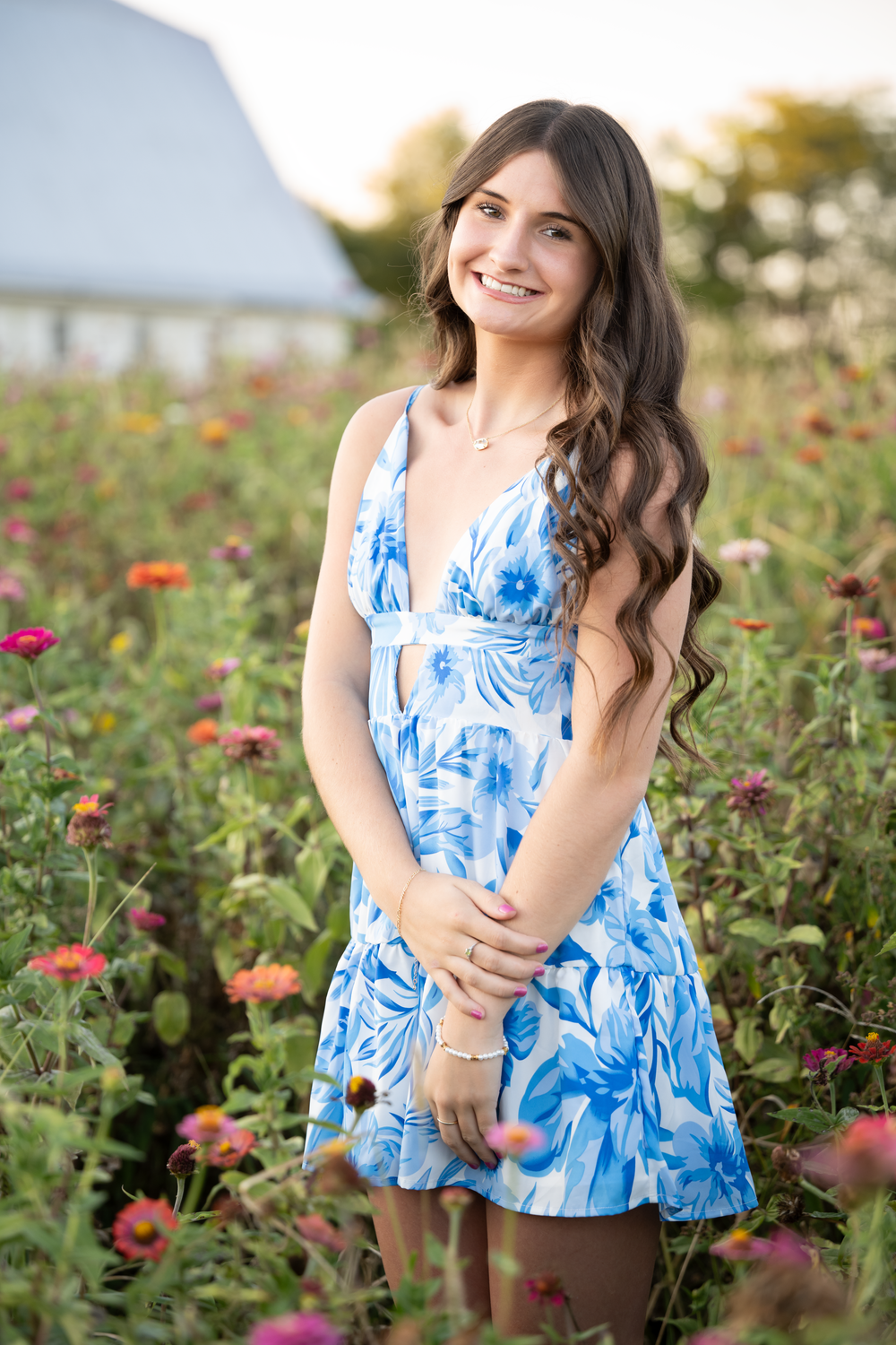 In a blue and white floral dress Kylie poses in the wildflowers. Cincinnati Senior Photography