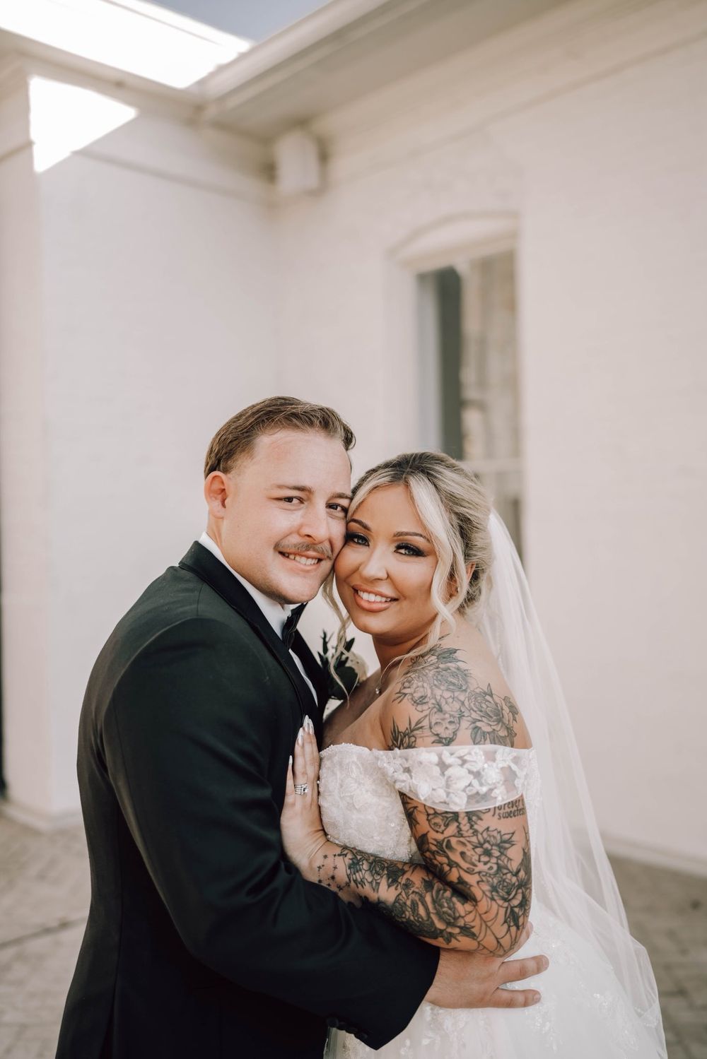 A romantic wedding couple shares intimate moments in a series of black and white portraits in a bright hallway.