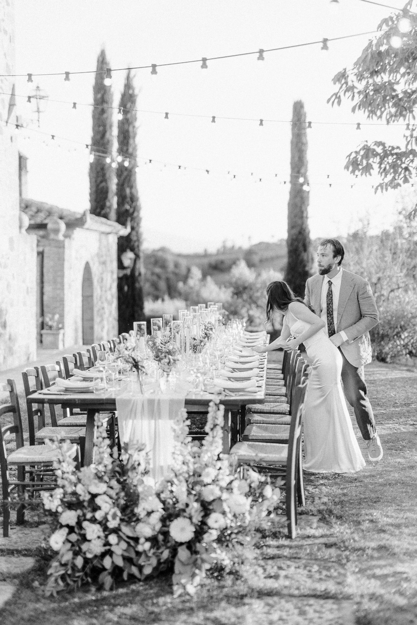 Wedding guests share joyful laughter during outdoor reception dinner at sunset.