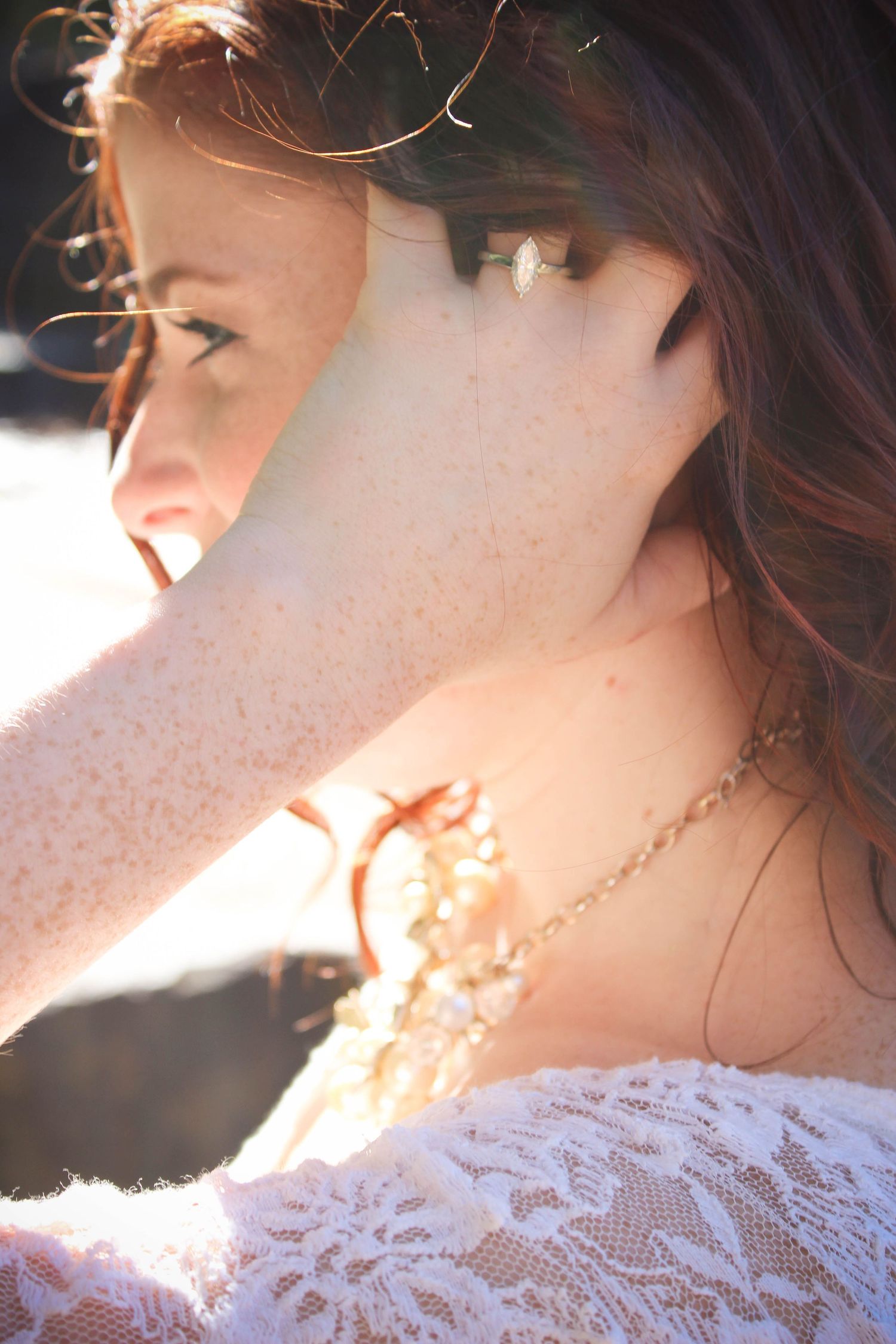 Sunlit profile of a person wearing a delicate white lace dress with soft light creating an ethereal glow.