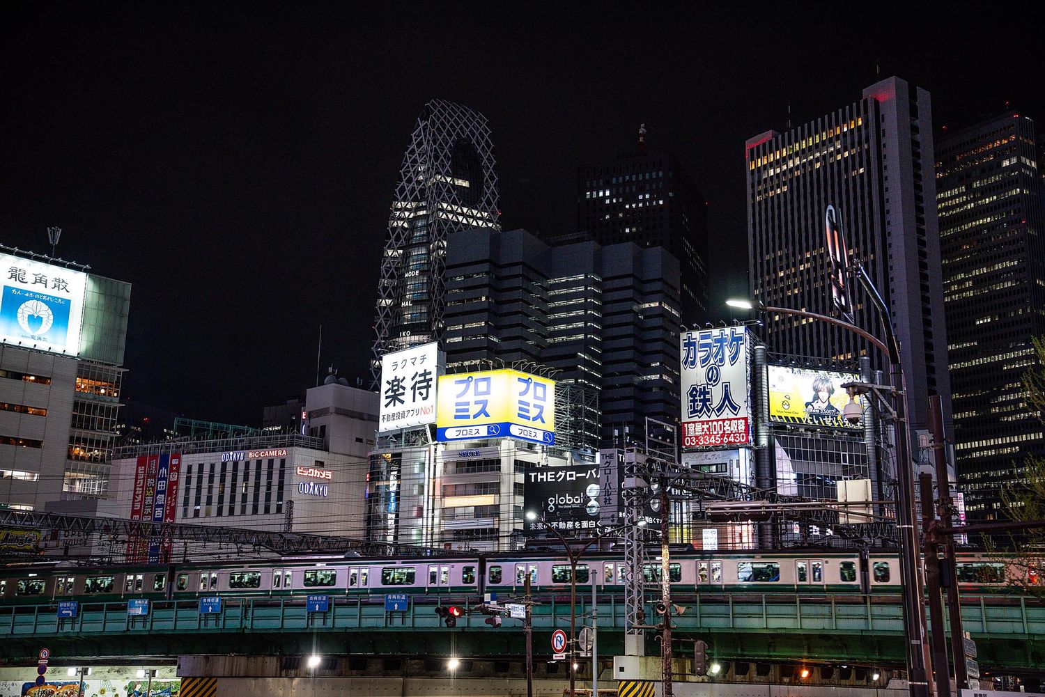 Vibrant nighttime cityscape of Tokyo with illuminated buildings and neon signs stretching across the horizon.
