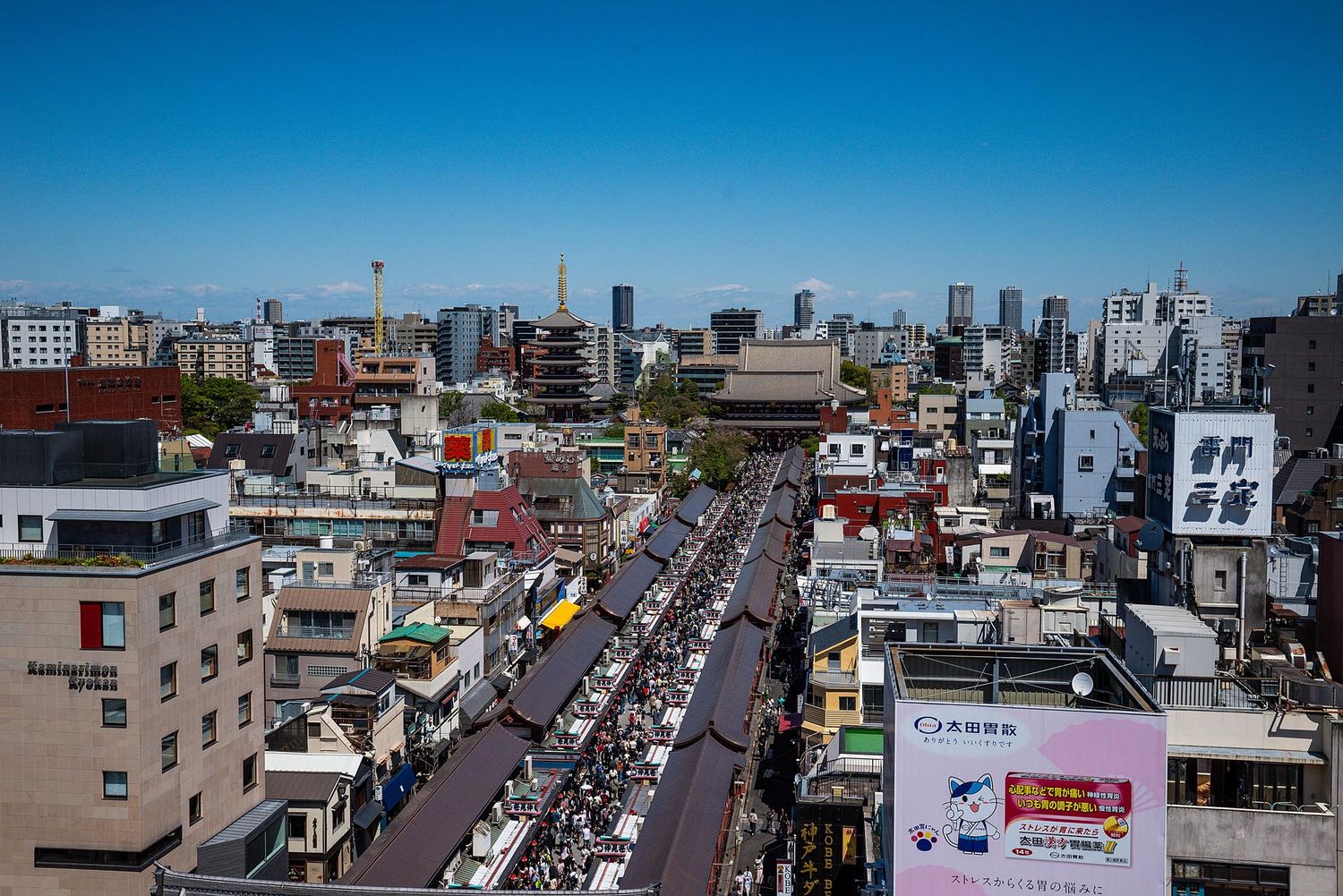 Aerial panoramic view of a busy city street with dense traffic and buildings stretching into the distance.