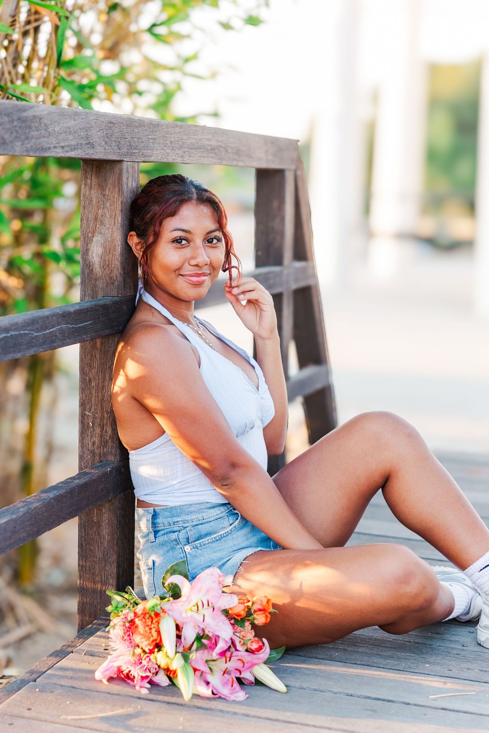 A collection of lifestyle portraits taken on a rustic wooden deck with colorful flowers in warm sunlight.