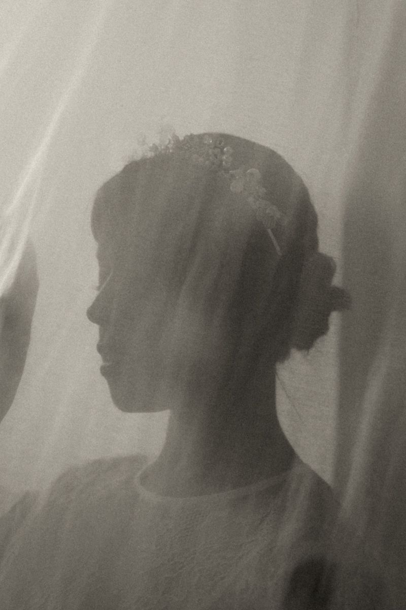 Artistic black and white silhouette series showing a figure behind sheer curtains in different poses.