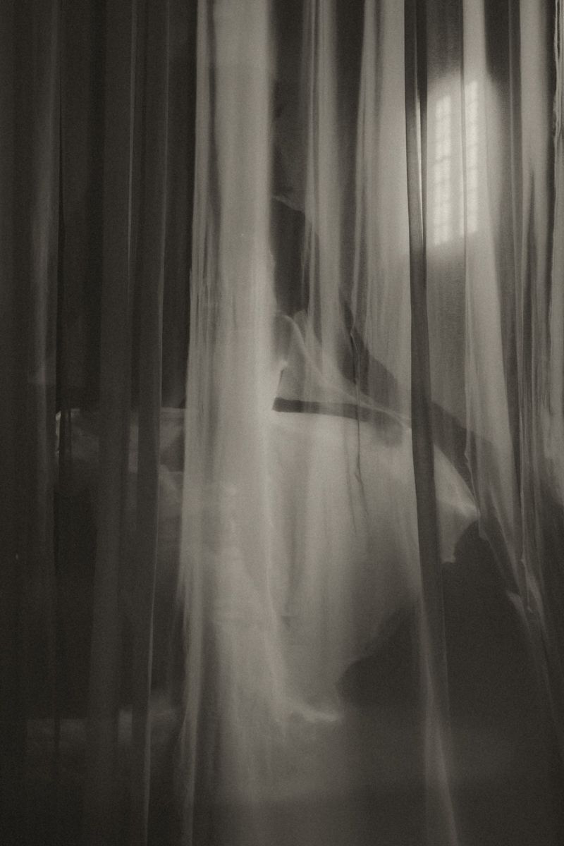 Moody black and white forest scene with blurred tree trunks creating an ethereal, haunting atmosphere.