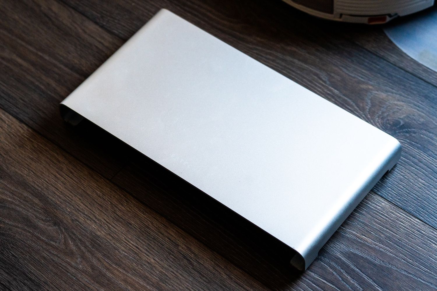 A series of seven photos showing a white laptop computer being opened at different angles on a dark wooden surface.
