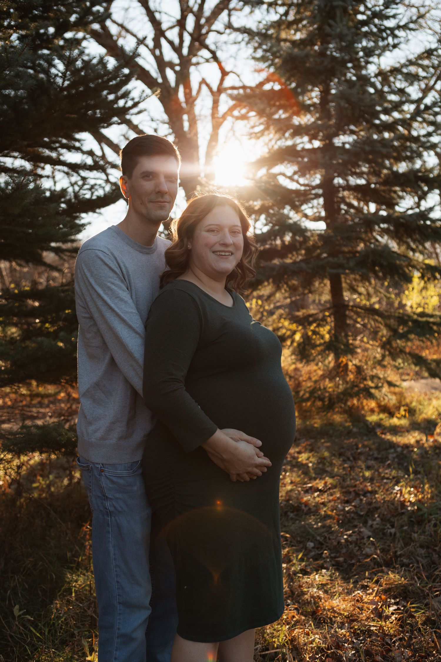 Expectant couple shares intimate moment during sunset maternity session.