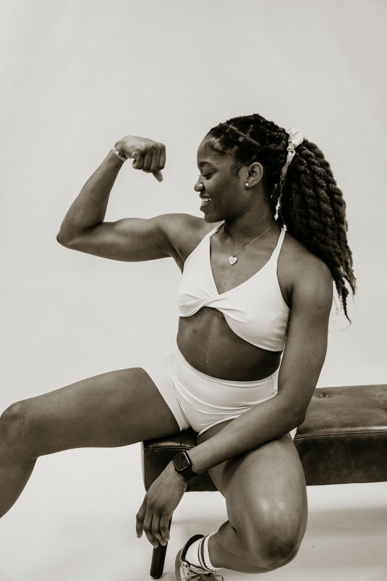 A series of black and white photos showing an athlete in white athletic wear demonstrating dynamic stretching poses.