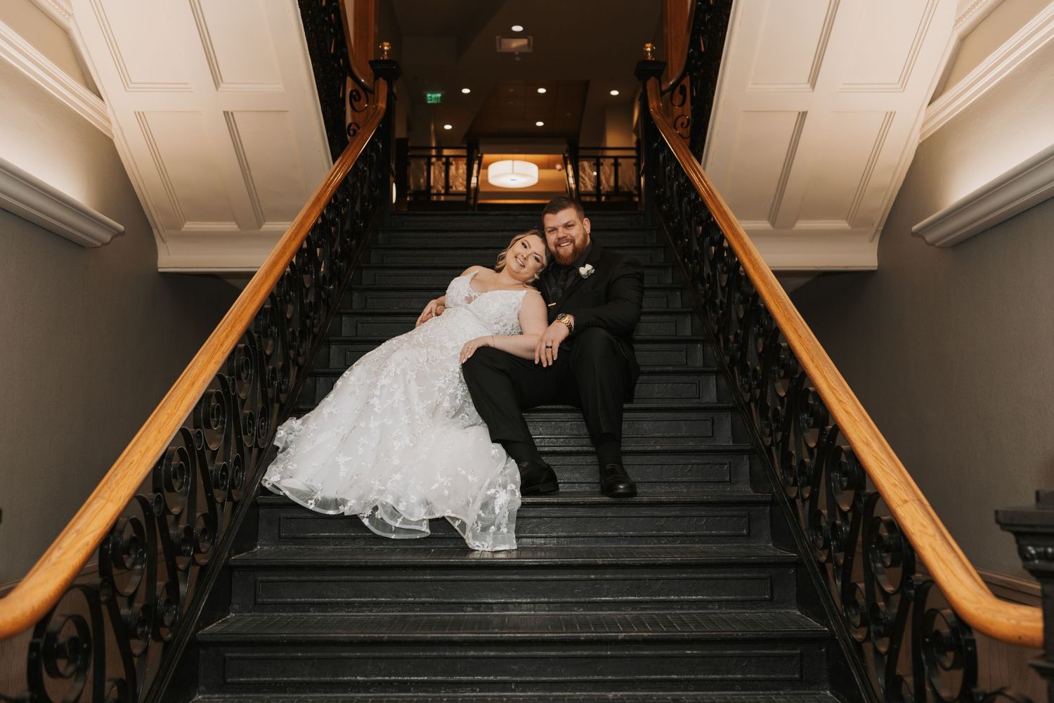 A series of romantic wedding photos taken on an elegant staircase with wooden railings.