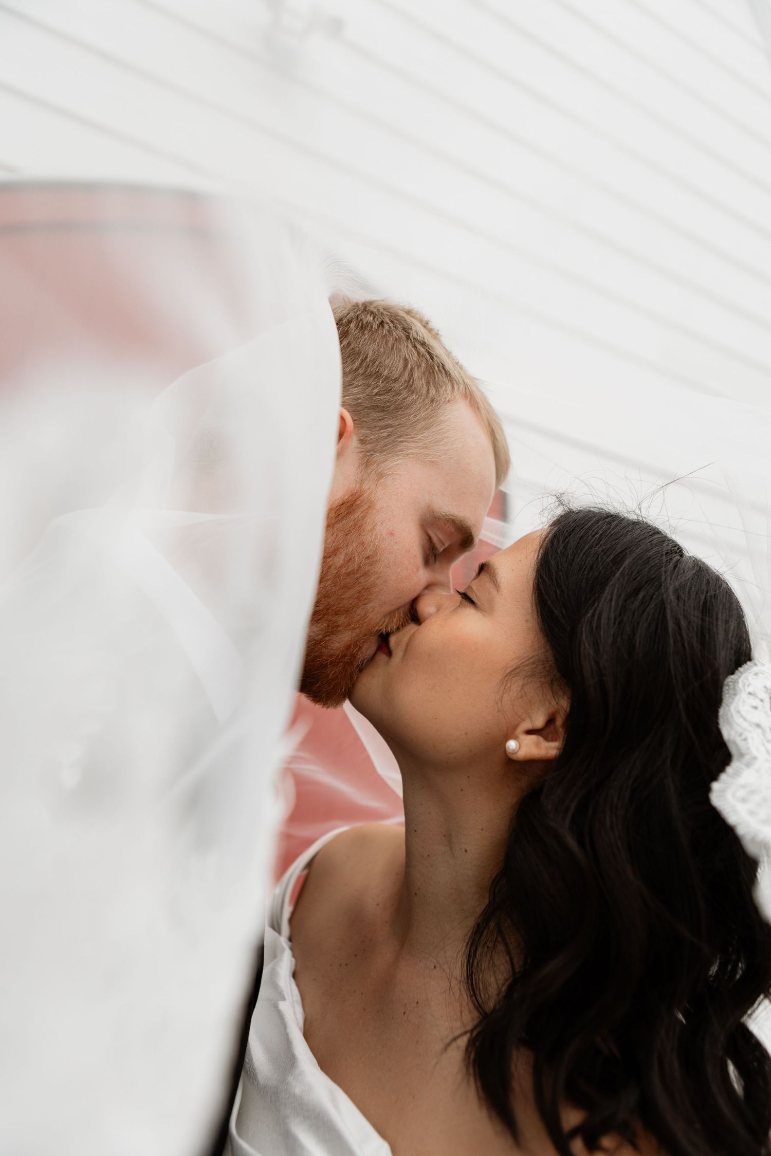 Intimate wedding portraits captured through white veil.