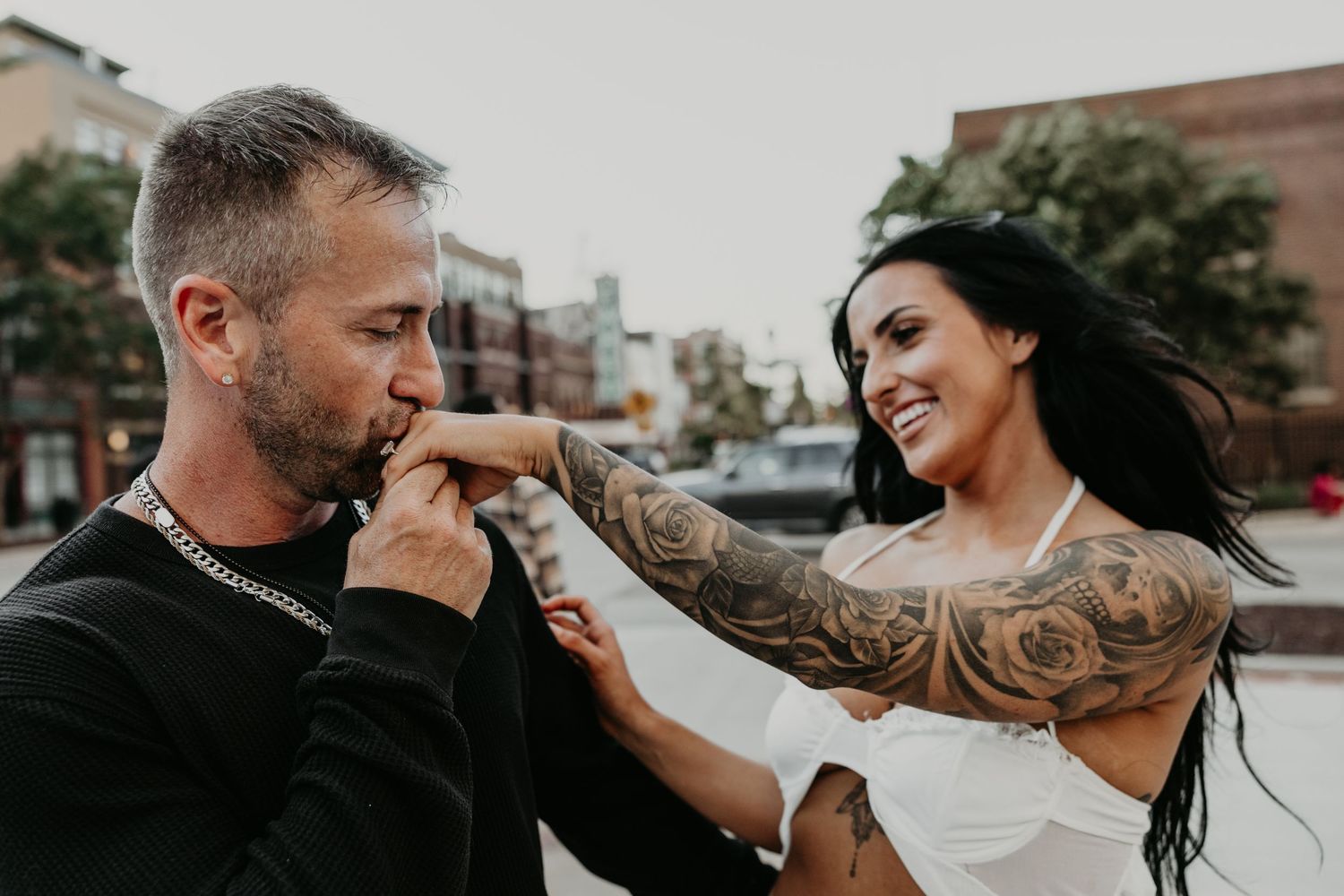 Romantic couple's photoshoot against urban brick buildings.