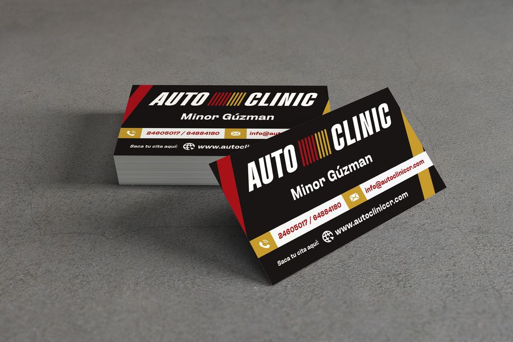 Black and red business cards for Auto Clinic displayed on dark gray surface.
