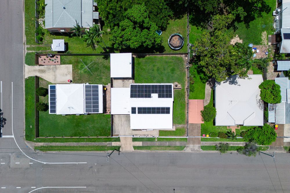 Aerial view of a residential neighborhood with green lawns and houses arranged along suburban streets.