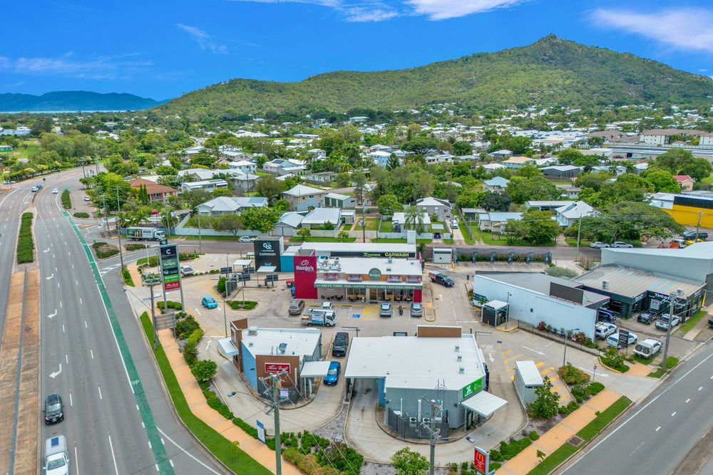 Aerial panoramic view of Kailua town with mountains, buildings, and roads under blue Hawaiian skies.