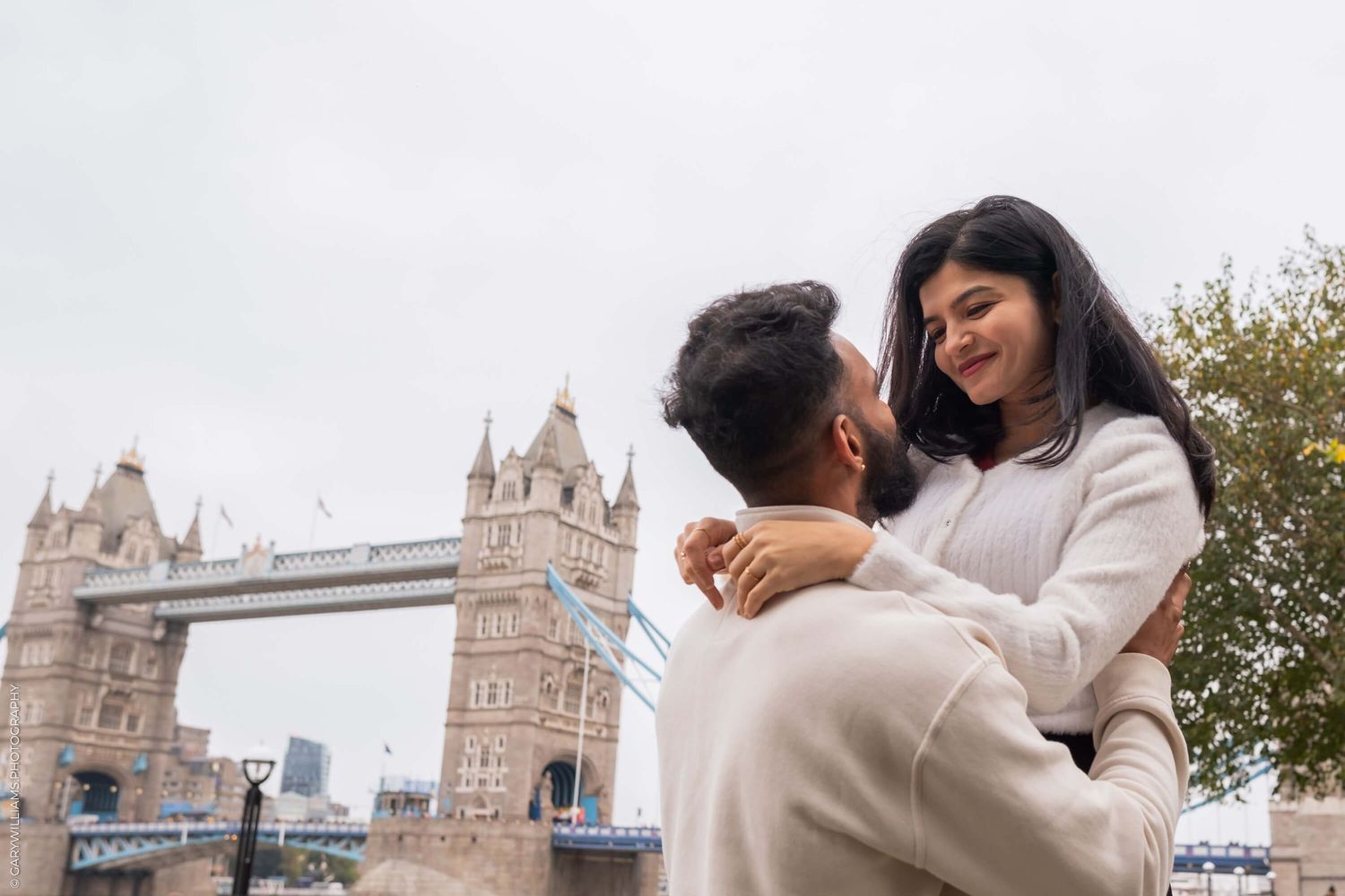 A romantic moment shared in front of Tower Bridge in London.