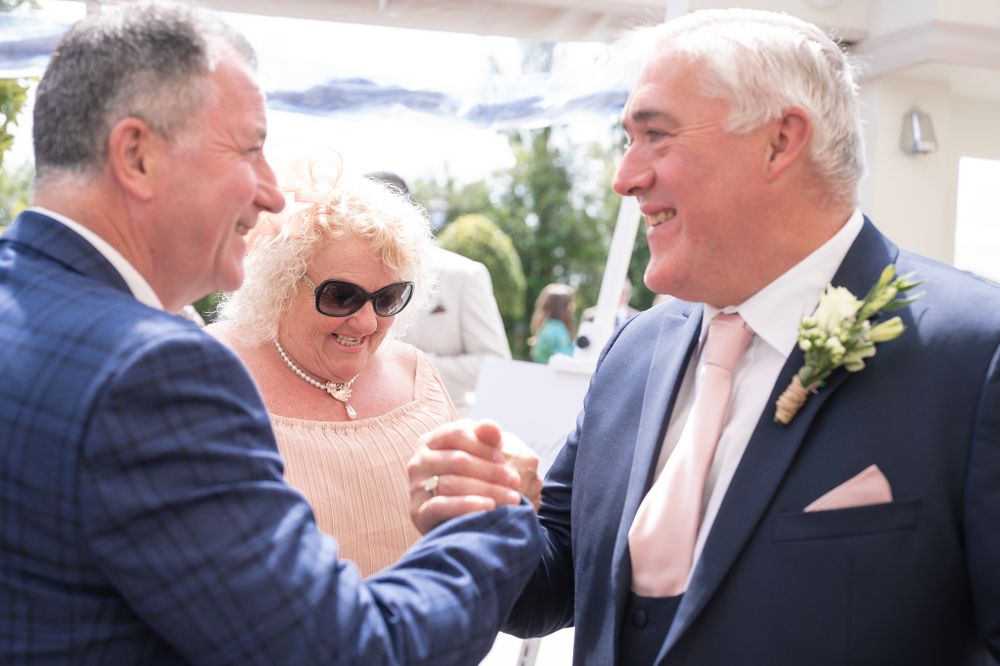 Guests enjoying conversation during an outdoor wedding celebration.