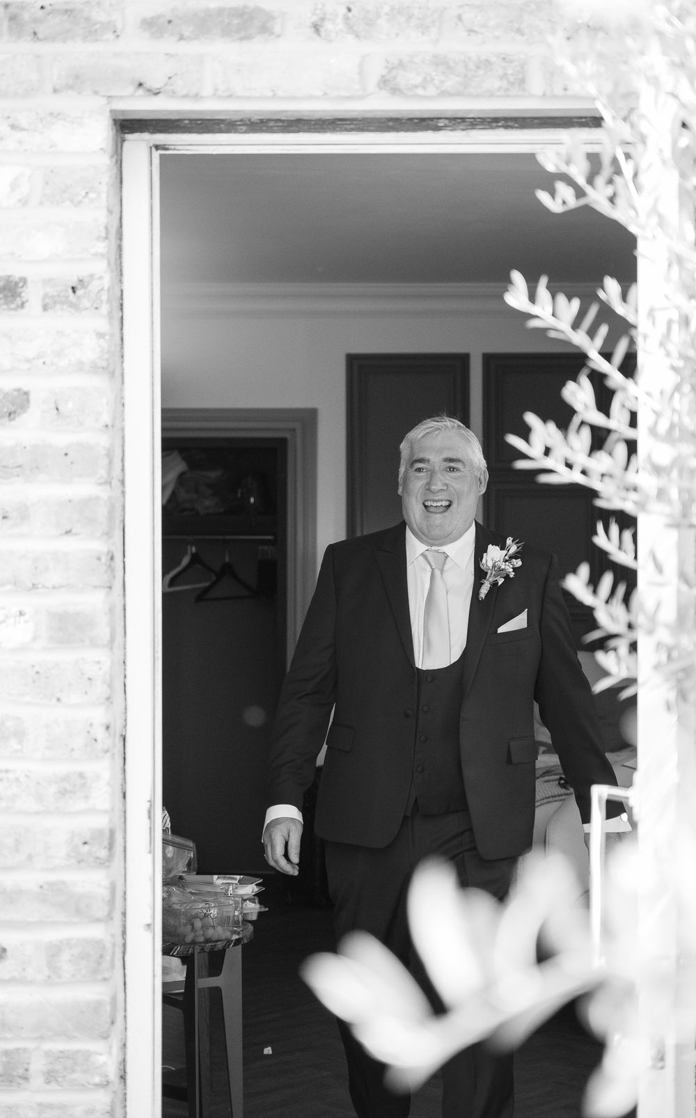 Black and white portrait through doorway with decorative snowflake elements in foreground.