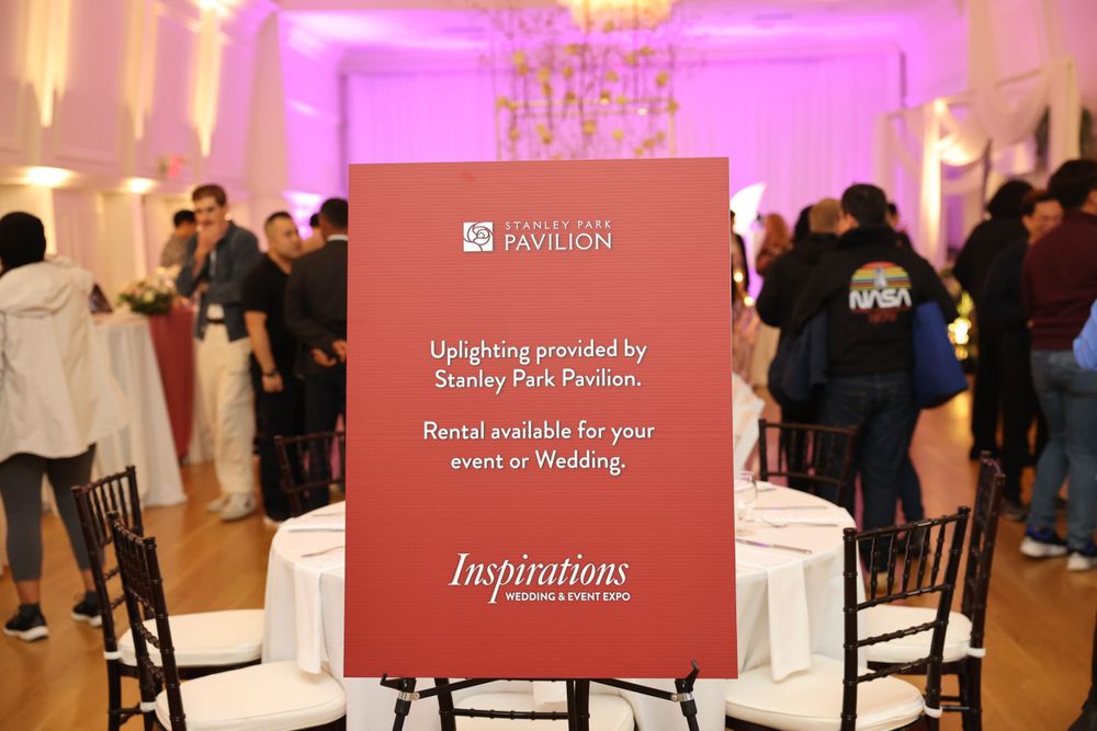 A red event signage for Stanley Park Pavilion displaying rental information in a decorated venue.