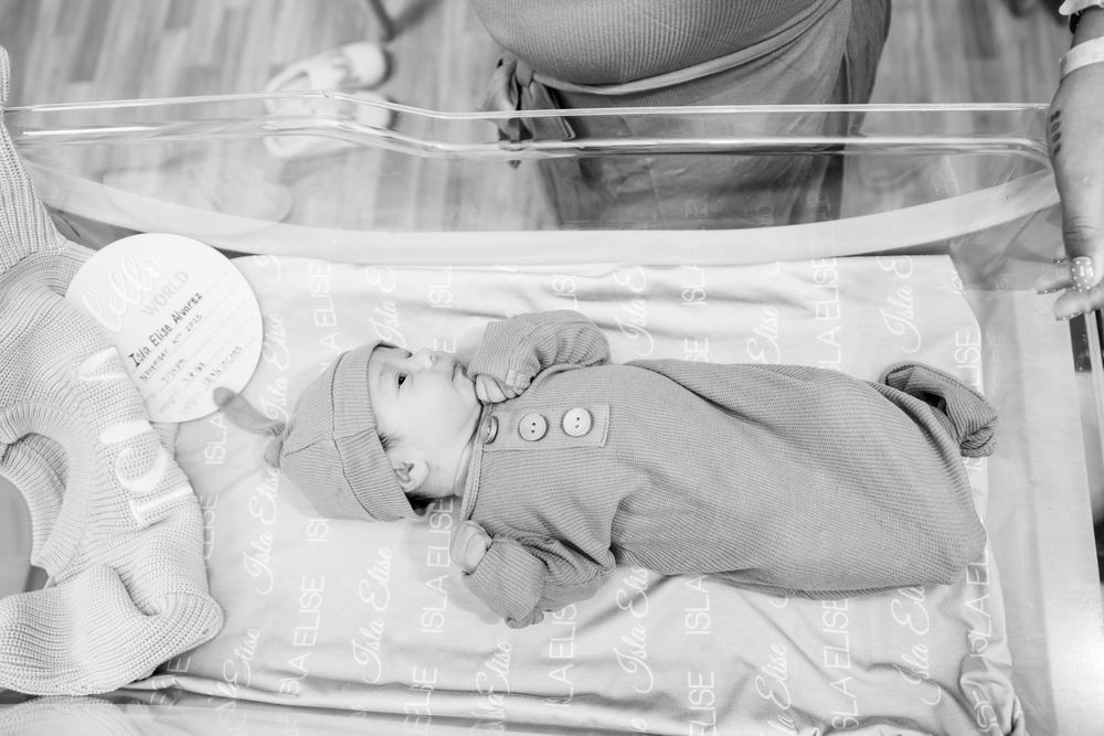 Four black and white medical photos showing a newborn baby in different positions during examination.