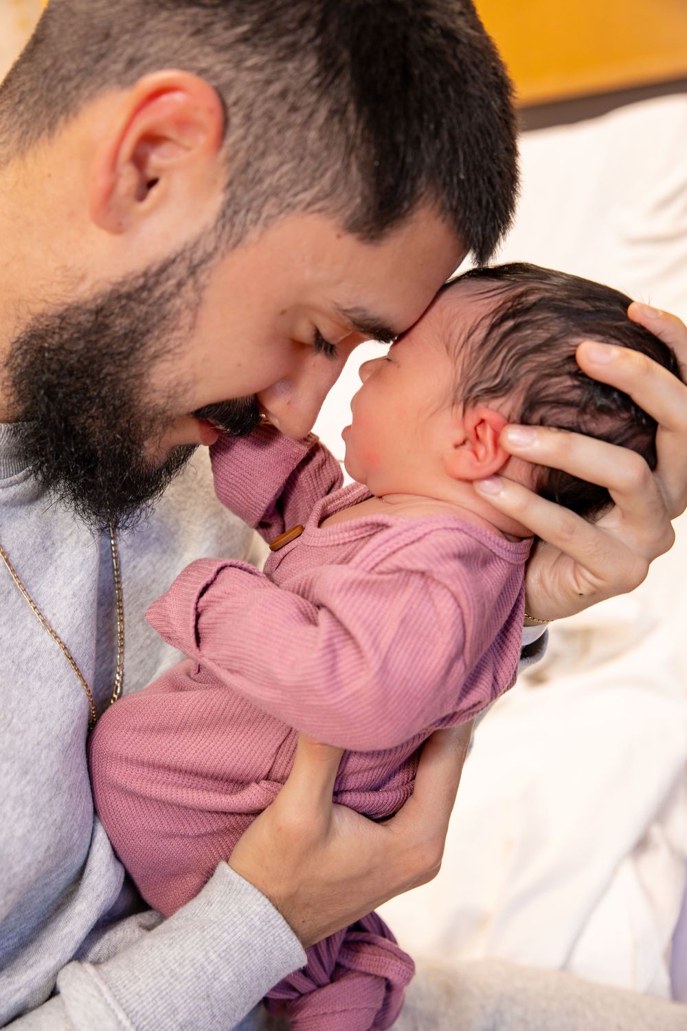 A bearded person in a gray sweater shares tender moments with a child wearing pink in a progressive sequence.